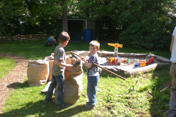 Kinder und Eltern bei der Gartenarbeit auf dem Schulhof